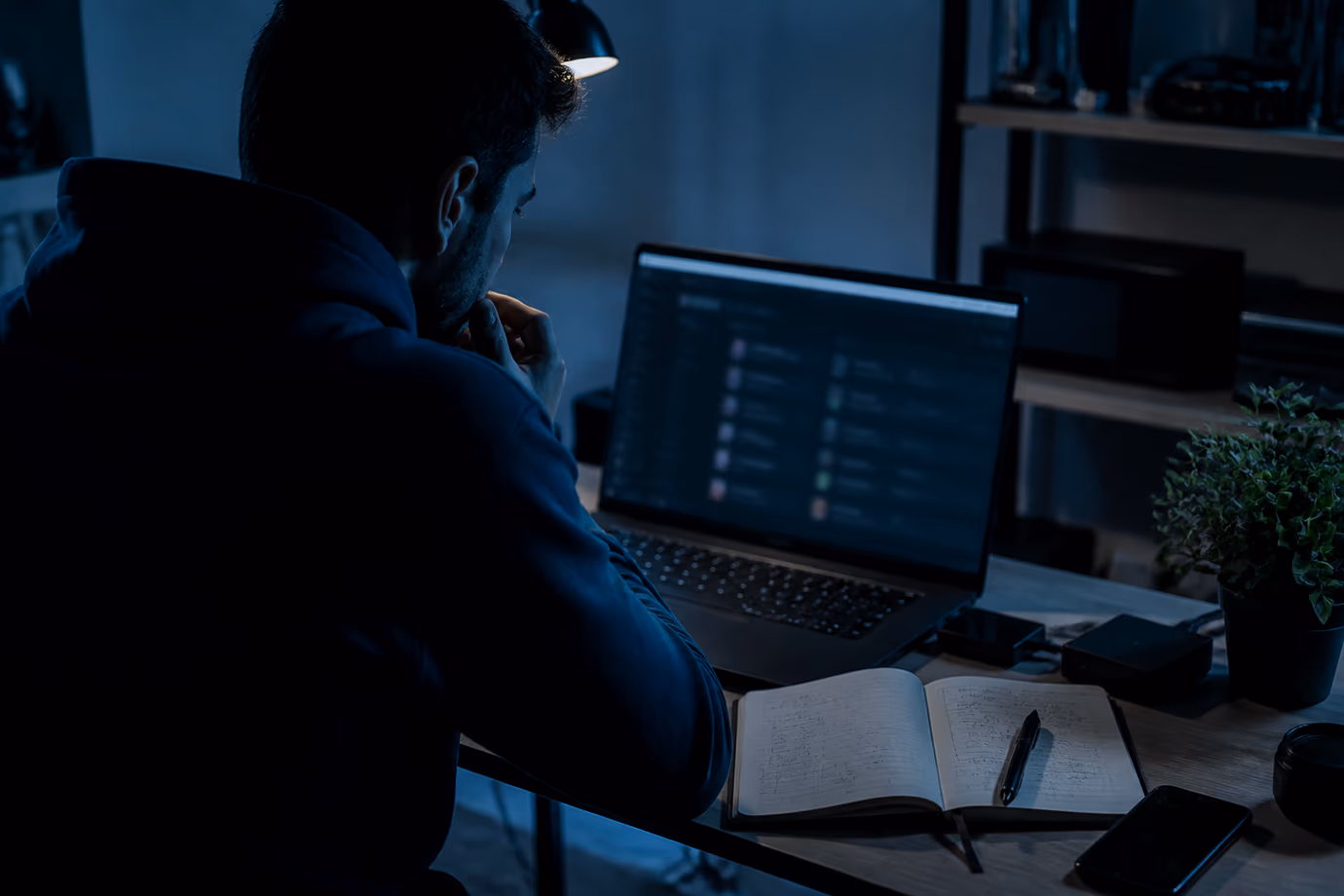 A user analyzing dark web marketplaces in a dimly lit room.